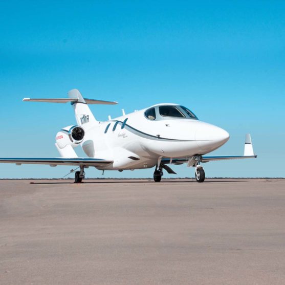 Picture of White HondaJet Elite with Grey and Blue Stripes. BlueSky, on Clean Tarmac.